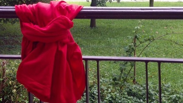 Un tessuto rosso alle finestre per dire no alla violenza contro le donne