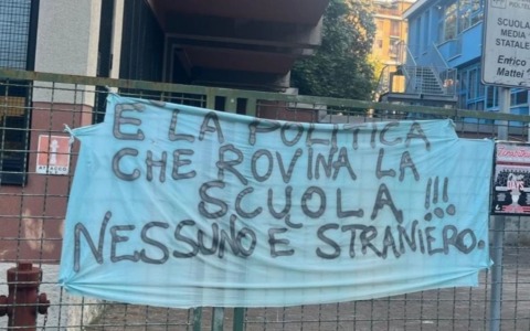 Sui cancelli della scuola compare uno striscione: “Fuori la politica dalla scuola. Nessuno è straniero”: i carabinieri lo rimuovono